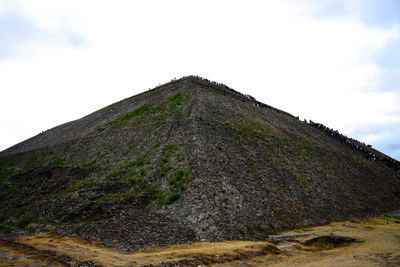 Low angle view of rocky mountain against sky