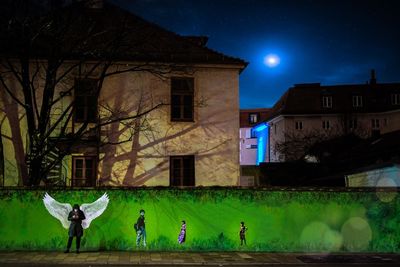 People playing in front of buildings at night