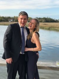 Portrait of cheerful couple standing by lake