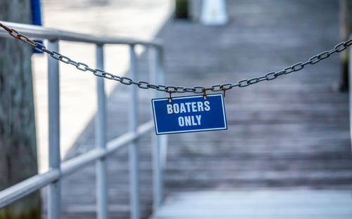 Close-up of warning sign on metal fence