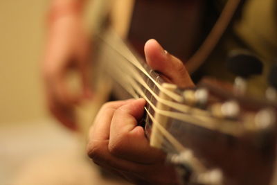 Close-up of person playing acoustic guitar