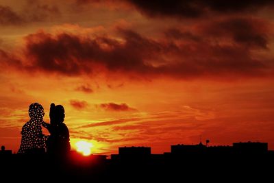 Silhouette of building against dramatic sky