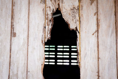 Close-up of hole in wooden wall