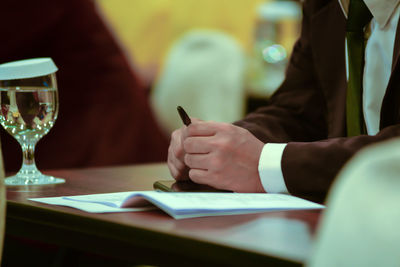 Midsection of businessman working on table