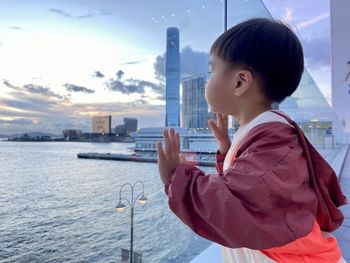 Side view of asian boy looking at sea