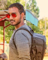 Portrait of young man wearing sunglasses standing outdoors