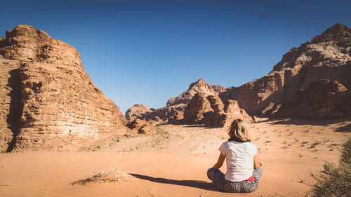 Women sitting by rock