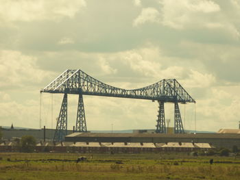 Suspension bridge against cloudy sky