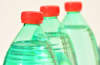 Close-up of water bottles against beige background