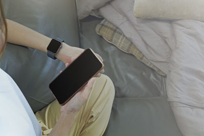 High angle view of man using mobile phone on bed