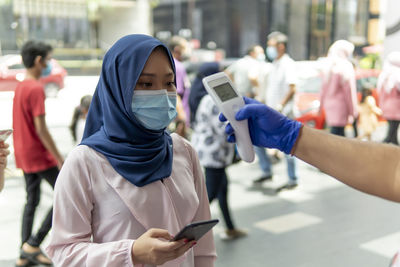 Midsection of woman holding mobile phone