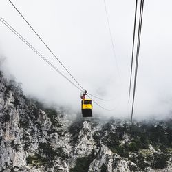 Low angle view of overhead cable car against sky