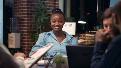 Young woman using laptop while sitting at office