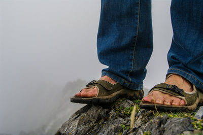 Low section of man standing on rock