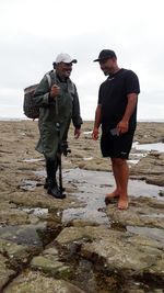 Full length of friends on shore at beach