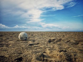 Surface level of ball on beach against sky