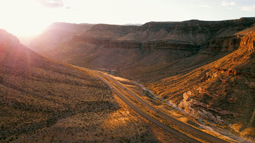 Scenic view of rocky mountains and highway road  during sunset