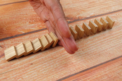 Cropped hand amidst wooden blocks at table