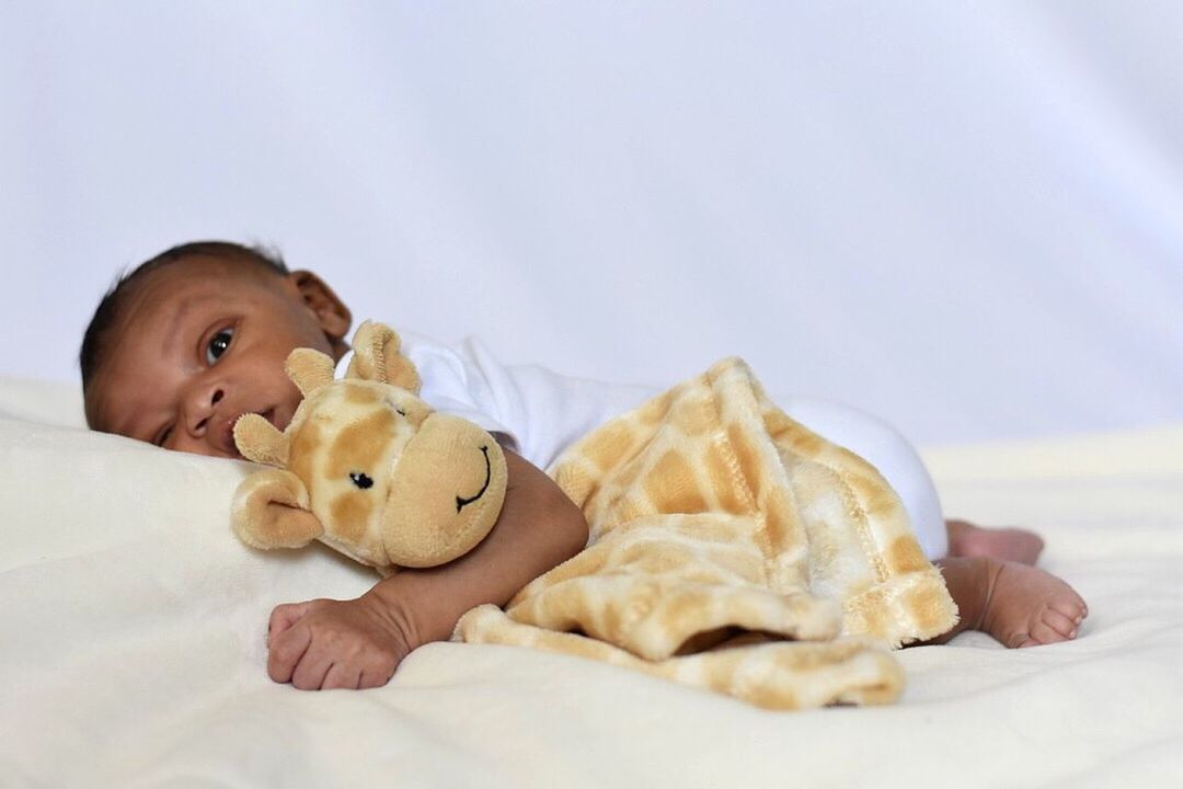 PORTRAIT OF CUTE BOY LYING ON BED