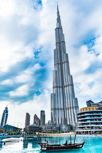 Modern buildings in city against cloudy sky
