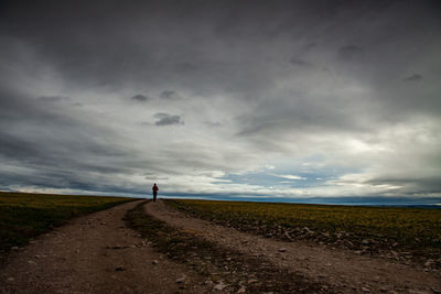 Road amidst field against sky