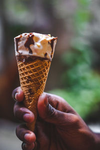 Close-up of hand holding ice cream cone