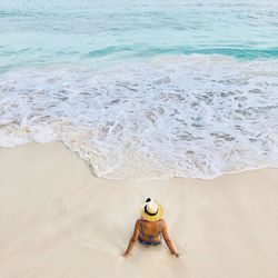 High angle view of woman sitting on beach