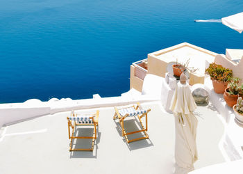 High angle view of people sitting on chair by sea