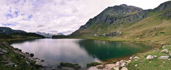 Scenic view of lake by mountains against sky