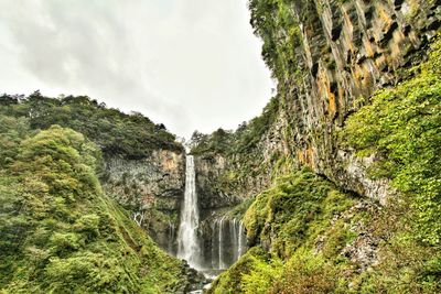 Scenic view of waterfall against sky