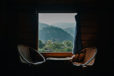 Empty chairs and tables against window