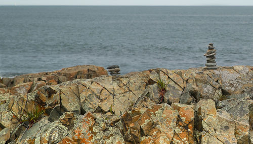 Scenic view of rocks on beach against sky