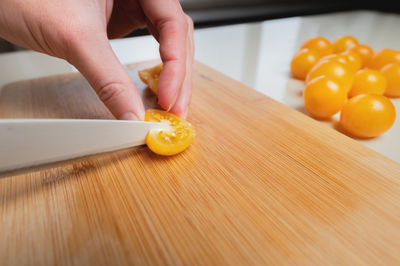 Sliced yellow cherry tomatoes on a wooden board in shallow depth of field against the background of