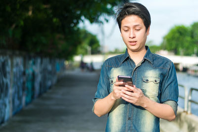 Full length of young man using mobile phone