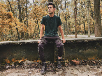 Portrait of young man sitting in forest