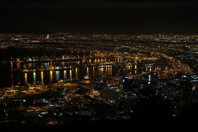 Illuminated city against sky at night