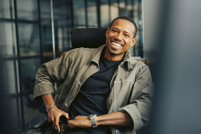 Confident male entrepreneur sitting on chair at office