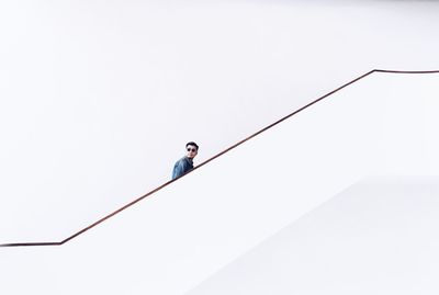 Low angle view of man on rope against clear sky