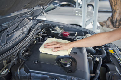 Hand cleaning car engine with a rag,worker
