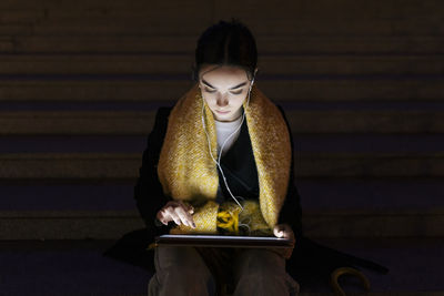 Teenage girl using laptop sitting on steps