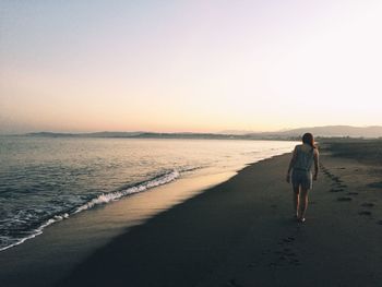 Full length rear view of a woman walking on beach