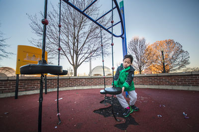 Boy sitting on outdoor play equipment in playground