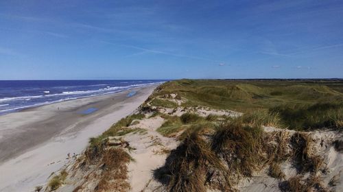 Scenic view of beach against blue sky