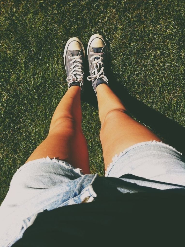 low section, person, lifestyles, leisure activity, personal perspective, shoe, human foot, relaxation, grass, standing, jeans, sitting, high angle view, footwear, barefoot, field