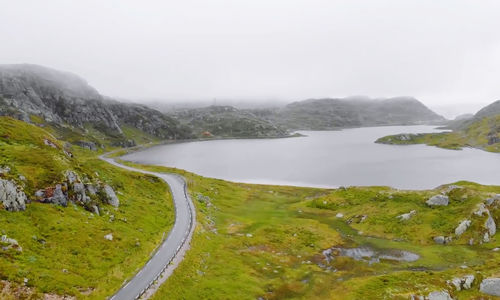 Scenic view of lake by mountains against sky