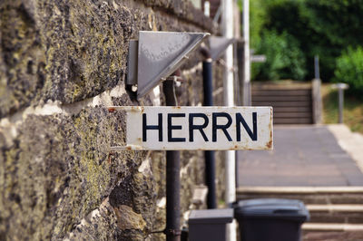 Close-up of road sign on old wall