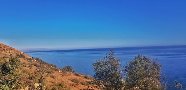 Scenic view of sea against clear blue sky