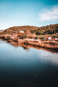 Scenic view of lake by buildings against sky