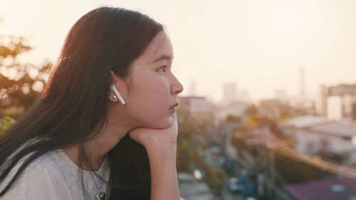 Portrait of young woman looking away in city