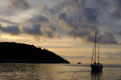 Sailboat sailing on sea against sky during sunset